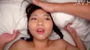 Pigtailed asian doll with natural boobs goes facial on the bed