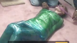 Fetish chick loves being wrapped in green plastic with her shaved pussy