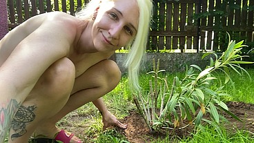 Hairy girl nude outside planting a plant