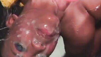 Ebony MILF has her face glazed in jizz during a massive bukkake session