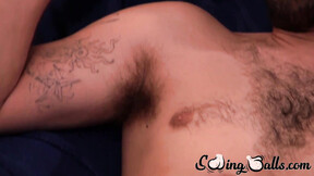 Bushy gay with shaved balls strokes meat while watching porn