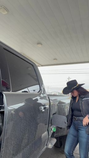 Woman in cowboy hat at gas station