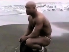 Asian bodybuilder barely covered at the beach