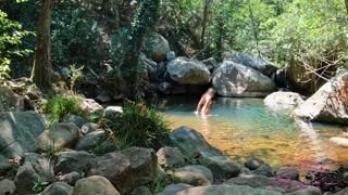 VOYEUR ON A GIRL BATHING IN A SUNNY STREAM