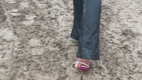 A girl in high-heeled shoes with rhinestones accidentally found herself in the middle of a large mud field, the mud is very deep and impassable