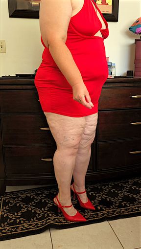 Beautiful social media model in mini red dress and high heels showing off