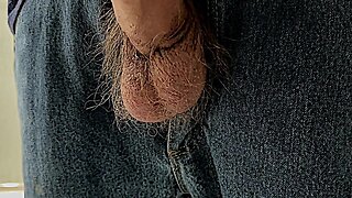 Semi-erect penis peeking out of jeans