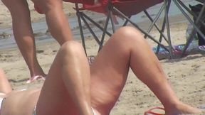 MILF with sexy legs on the beach voyeur video
