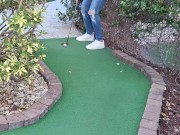 Small petite girl playing golf and not doing good at it