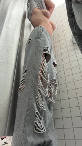 Hand holding ripped jeans