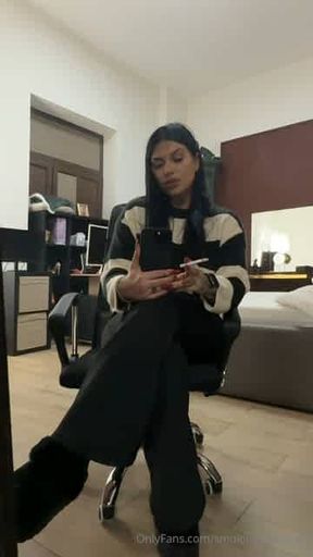 Girl smokes in front of the mirror