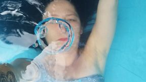 Underwater bubbles, rings and hair play wearing a blue swimsuit