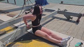 Kim flexes her beautiful muscles next to the sea