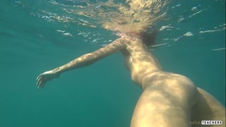 Nude model swims on a public beach in Russia