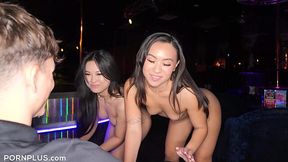 Two breathtaking asian strippers dance in font of a guy and then share his hard cock