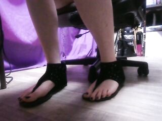 Candid feet in sandals beneath a table two