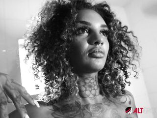 Marvelous tattooed black chick rubs her unshaved twat