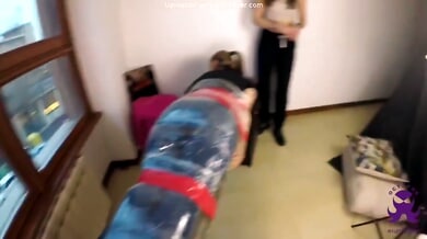 Bound woman restrained in plastic and tape while feet are touched and tickled