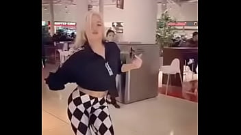 preciosa rubia bailando en el centro comercial