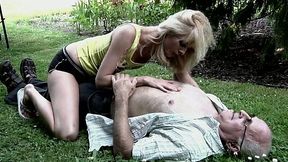 Alluring blonde doll gives head to an old guy in the park