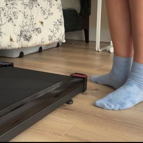 girl takes off wet white socks after treadmill