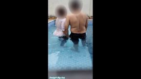Couple makes out and enjoys a dip in the pool with their big butts touching.