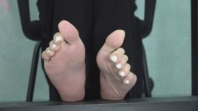 Meng Meng in a black beanie, flexes her feet and toes