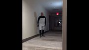 Giant cock barely contained by wetsuit while walking in hotel hall