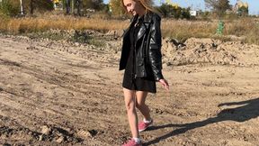 girl in sneakers and snowy white socks walks through the mud, she feels sorry for the sneakers, so she takes them off and walks through the mud in white socks