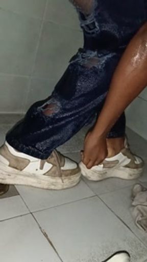 Wet girlfriend in the shower with jeans and sneakers