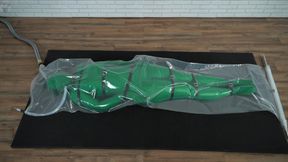 Green nylon zentai suit in a plastic vacuum bag bondage harness
