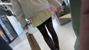 A girl walks in a short skirt without panties in a shopping mall