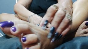 Woman with big nails on her hands scratching her feet (1)