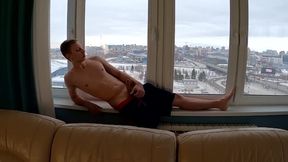 boy jacking off at the window overlooking the city