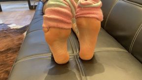 taking off her socks and showing off her pink soles.
