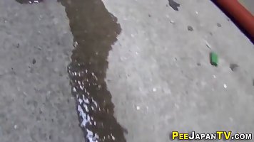 Japanese teen brunette with pigtails is peeing in a public place, in the middle of the day