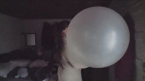 Blowing a balloon and wearing a white dress.