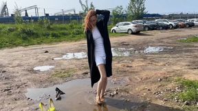 A girl in high-heeled shoes walks through the mud and tramples on her shoes, puts them on her dirty stockings