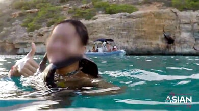 Chinese woman explores her body underwater during a beachside photo session