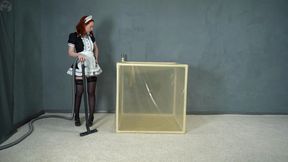 A maid locked in a transparent latex vacuum cube