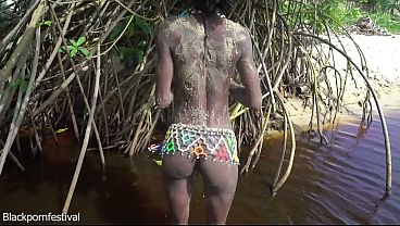 Skinny tribe girl with a body full of mud naked outdoor