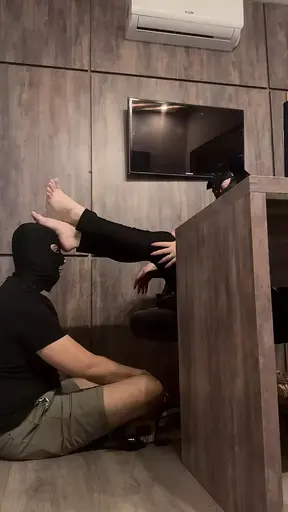 Boss orders his slave to massage his feet in the office