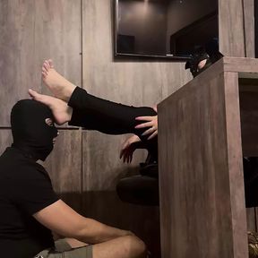 Boss orders his slave to massage his feet in the office