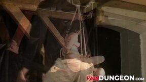 Gagged brunette is spanked by master in dungeon play