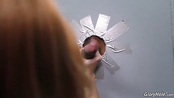 Red haired babe is getting fucked through a gloryhole and enjoying every single second of it