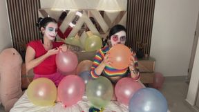 Two naked clowns playing with balloons