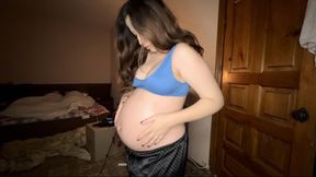 a pregnant woman anoints her tummy with oil from stretch marks