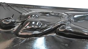 Girl in full encased in black latex catsuit enjoys her rubber vacuum bed