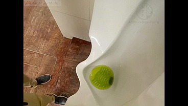 Amateur redhead guy caught pissing in a public toilet's urinal - he then quickly plays with his cock before leaving