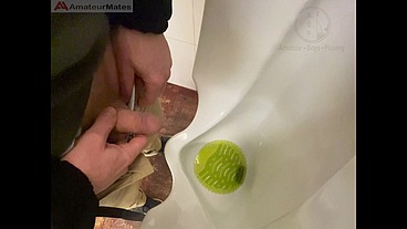 Amateur redhead guy caught pissing in a public toilet's urinal - he then quickly plays with his cock before leaving